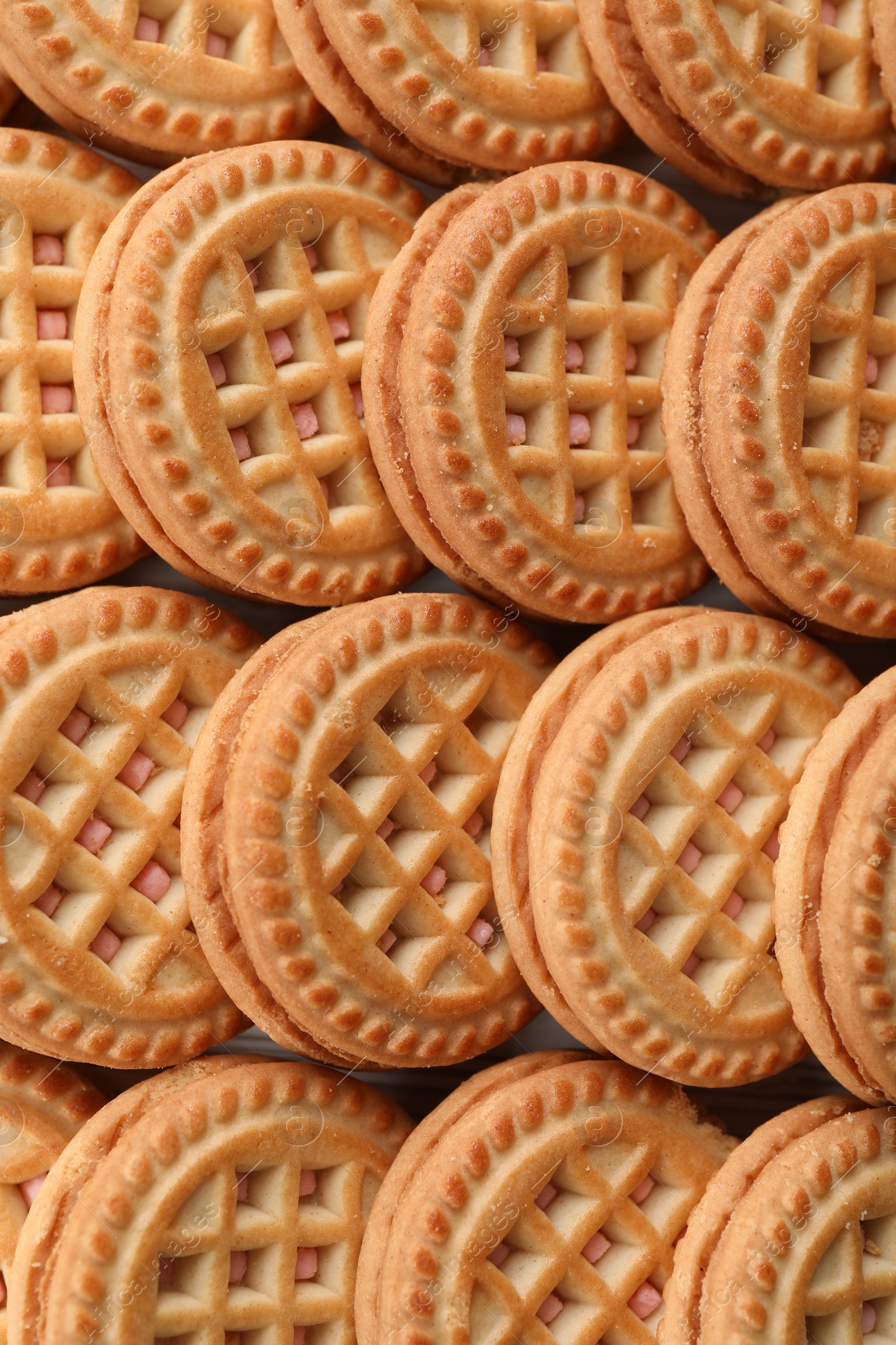 Photo of Tasty sandwich cookies with cream as background, top view