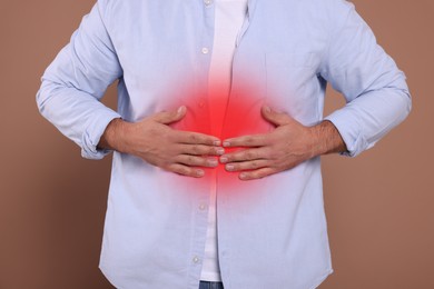 Image of Man suffering from stomach pain on brown background, closeup