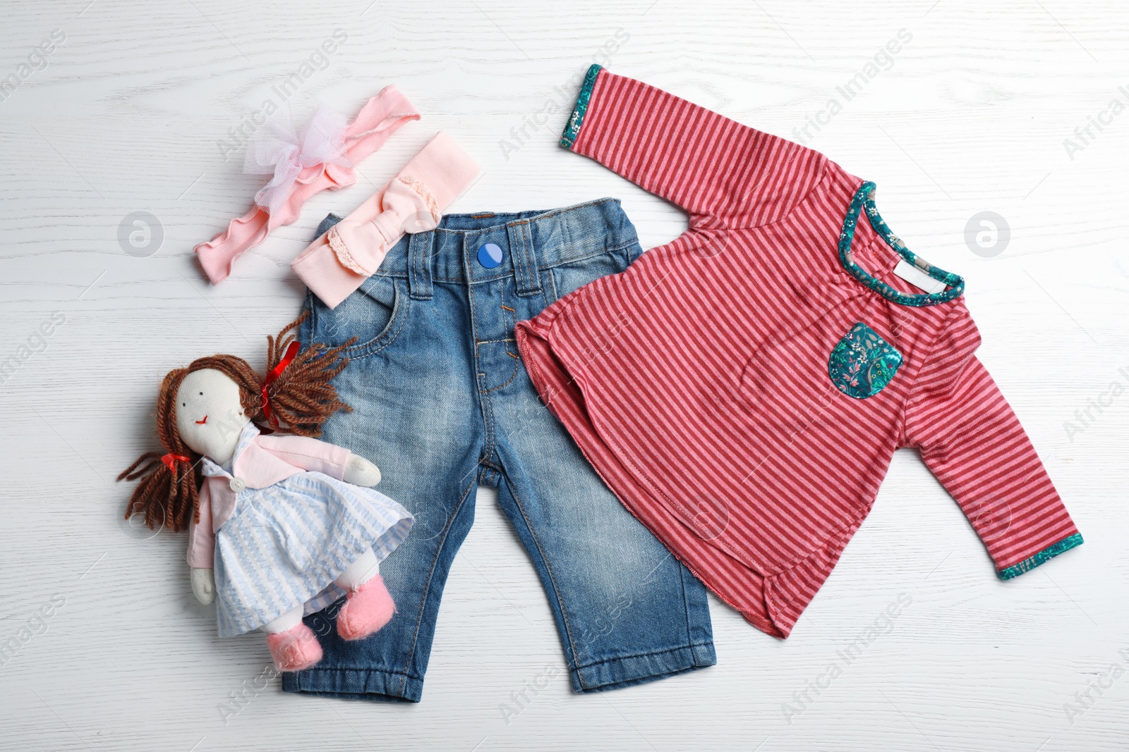 Photo of Flat lay composition with cute clothes on white wooden background. Baby accessories