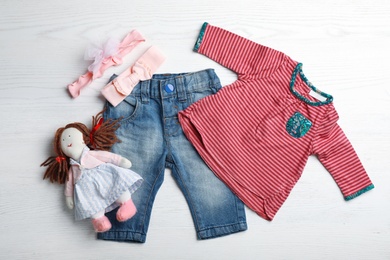 Flat lay composition with cute clothes on white wooden background. Baby accessories