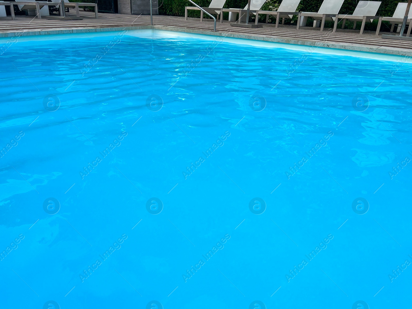 Photo of Outdoor swimming pool in luxury hotel on sunny summer day. Time for relax