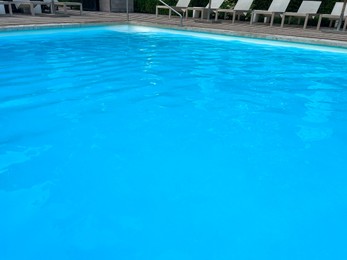 Outdoor swimming pool in luxury hotel on sunny summer day. Time for relax