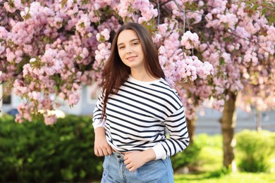 Beautiful woman near blossoming tree on spring day