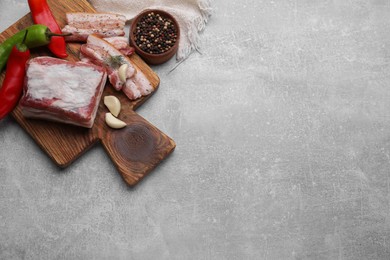 Photo of Tasty pork fatback with spices on grey table, flat lay. Space for text