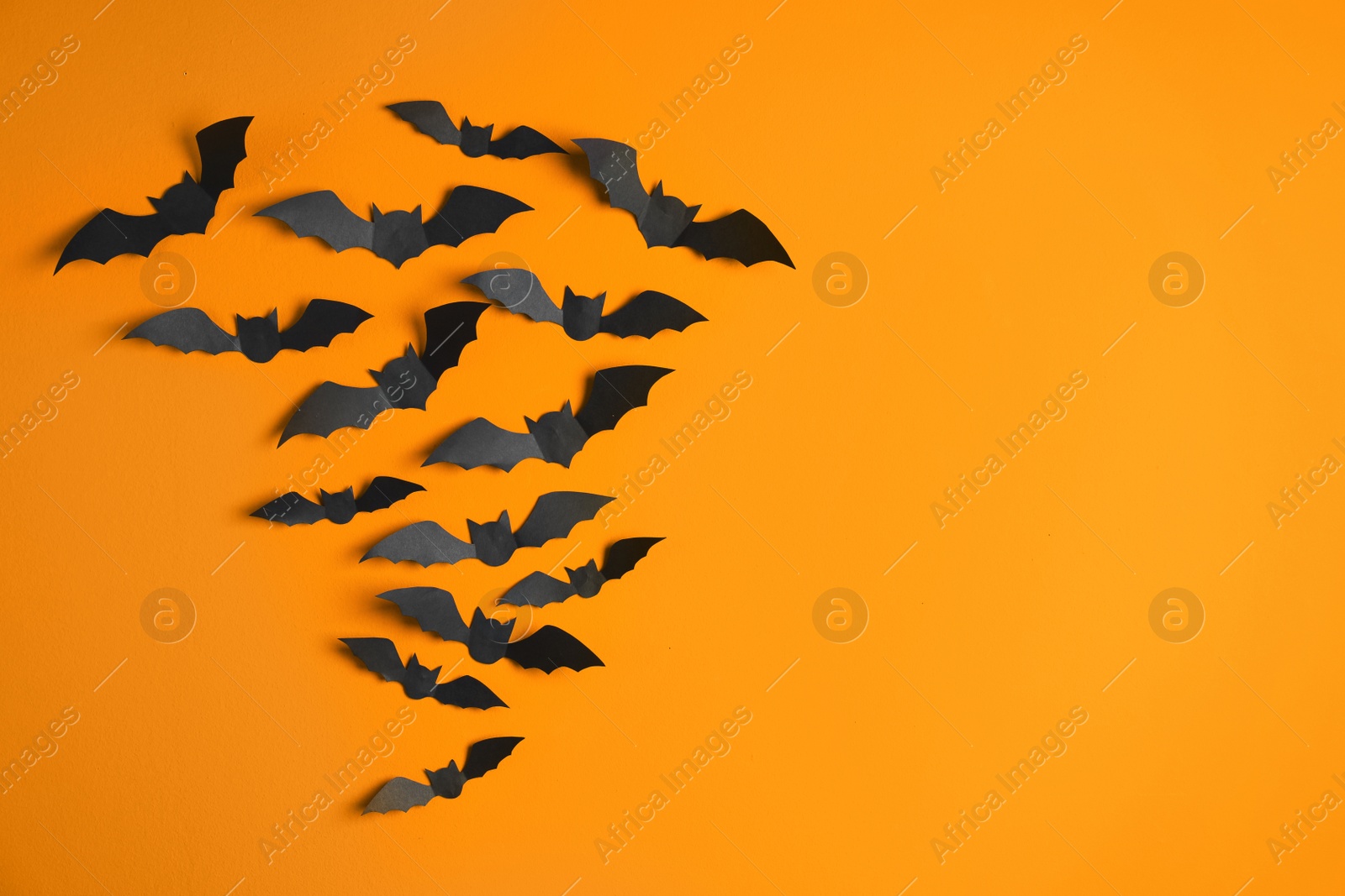 Photo of Paper bats on color background with space for text. Halloween decor