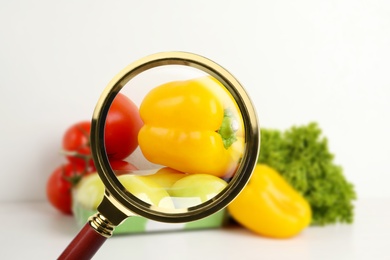 View through magnifying glass on vegetables, closeup. Poison detection