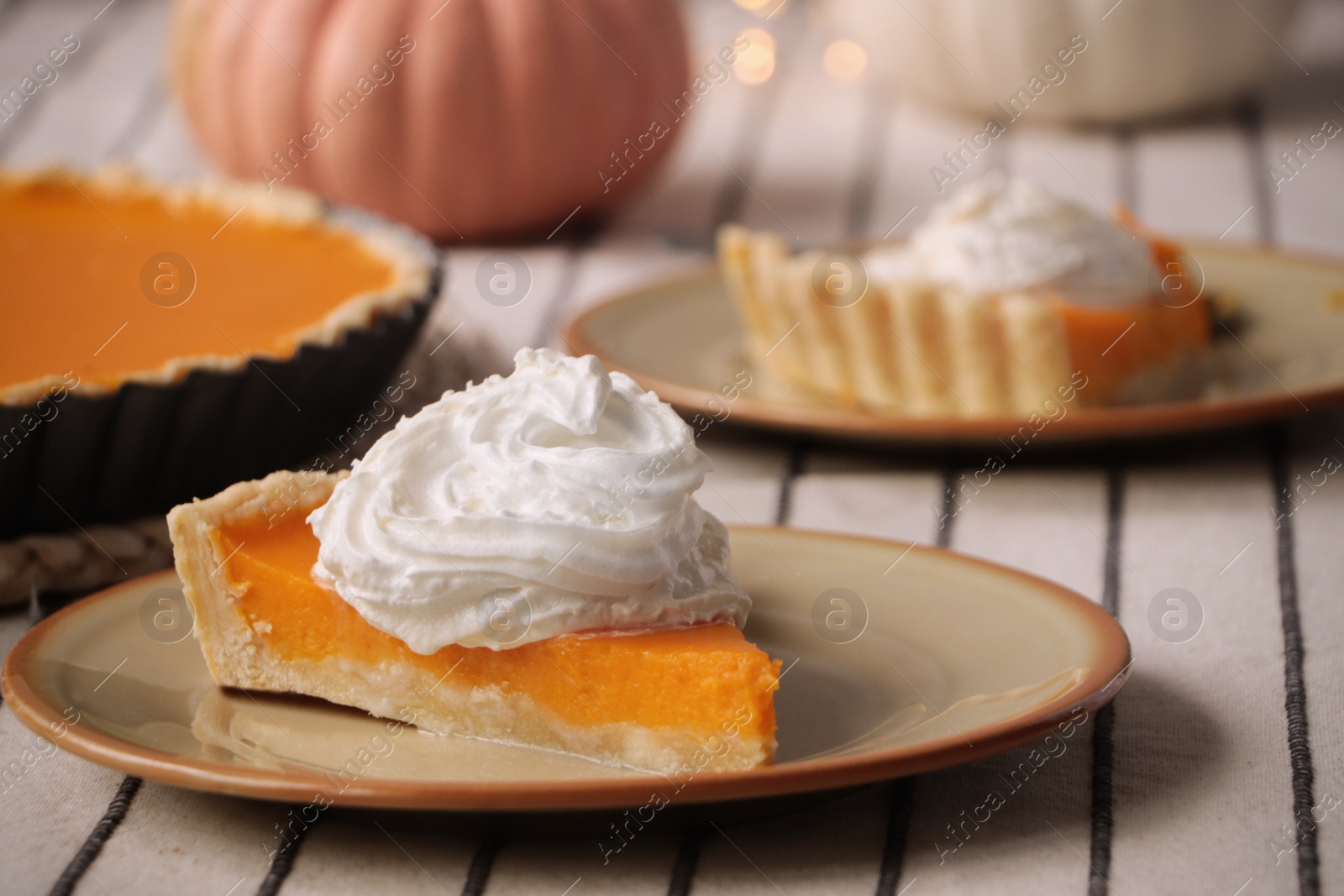 Photo of Piece of fresh homemade pumpkin pie with whipped cream on table