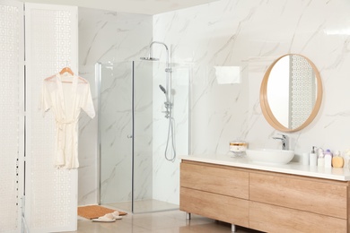 Photo of Modern bathroom interior with shower stall and folding screen