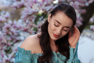 Photo of Beautiful woman near blossoming magnolia tree on spring day