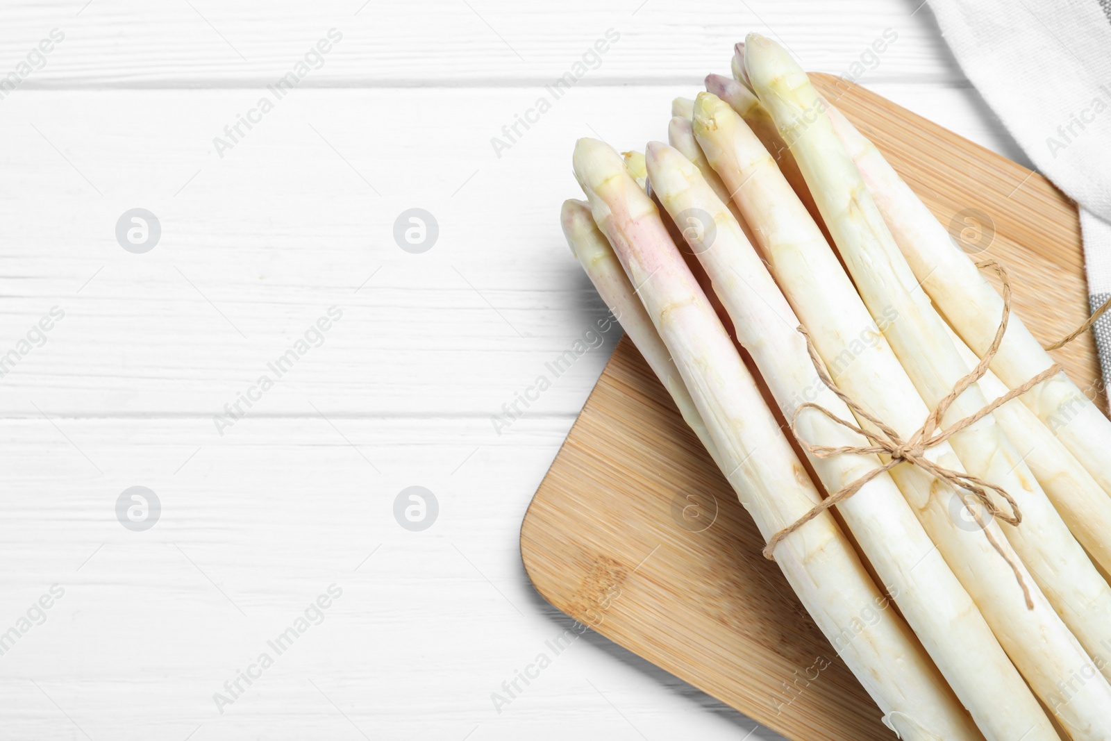 Photo of Fresh white asparagus on wooden table, top view. Space for text