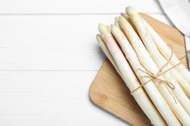 Photo of Fresh white asparagus on wooden table, top view. Space for text