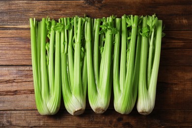 Fresh ripe green celery on wooden table, flat lay