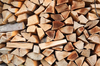 Photo of Stack of chopped firewood as background, closeup