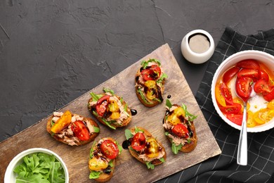 Photo of Delicious bruschettas with balsamic vinegar, tomatoes, arugula and tuna on grey textured table, flat lay. Space for text