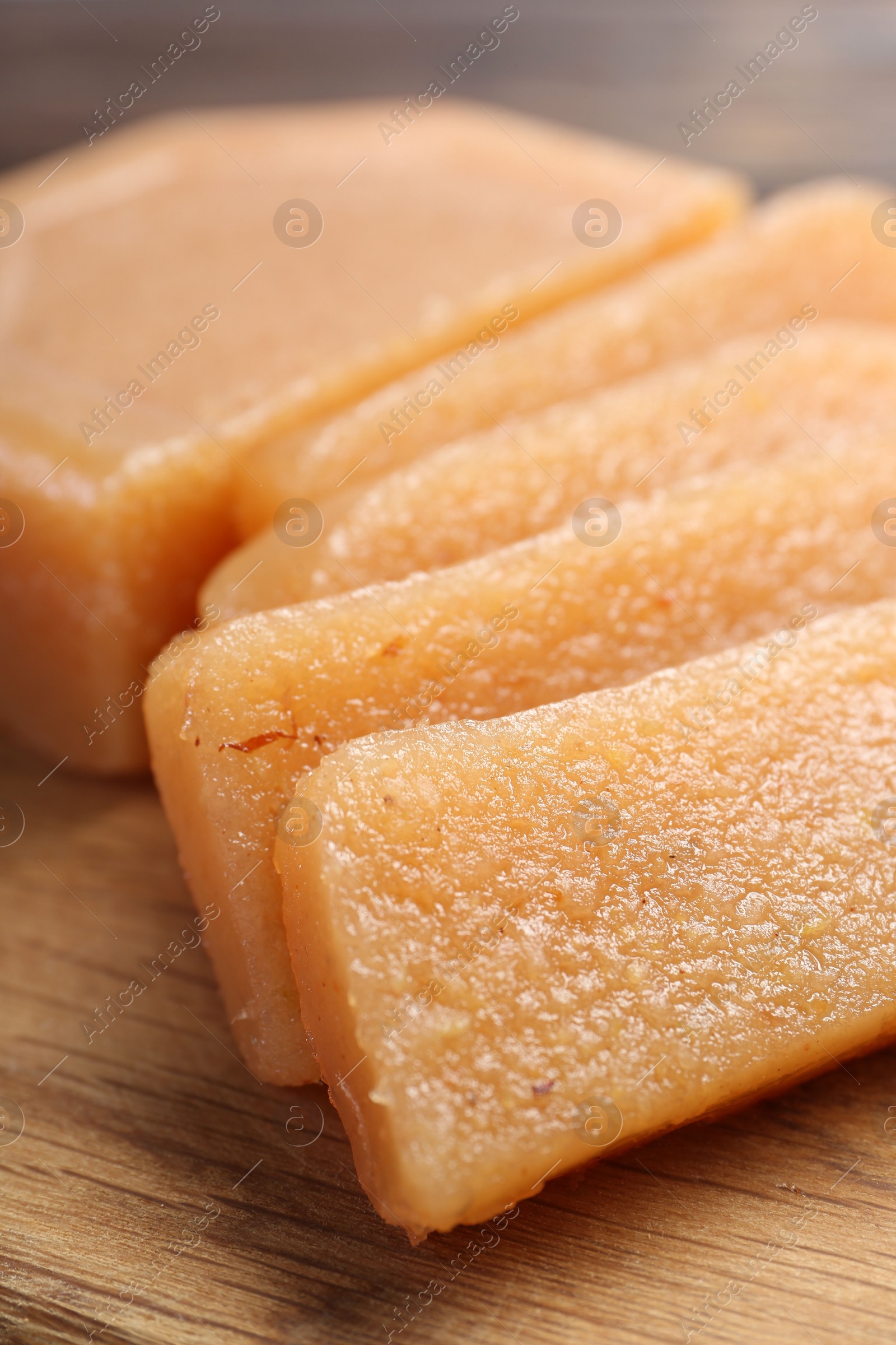 Photo of Tasty sweet quince paste on wooden board, closeup