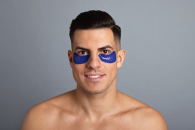 Photo of Man with blue under eye patches on grey background