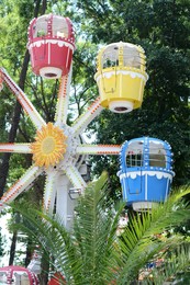 Photo of Observation wheel with colorful cabins in amusement park