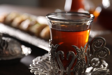 Glass of traditional Turkish tea in vintage holder on table, closeup. Space for text