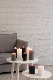 Burning candles on tables in living room