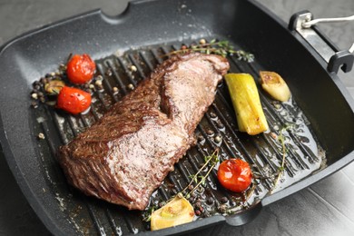 Photo of Delicious grilled beef meat and vegetables in pan on table, closeup