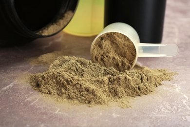 Photo of Measuring spoon and hemp protein powder on table