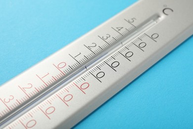 Weather thermometer on light blue background, closeup