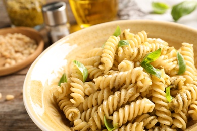 Photo of Plate of delicious basil pesto pasta on table, closeup