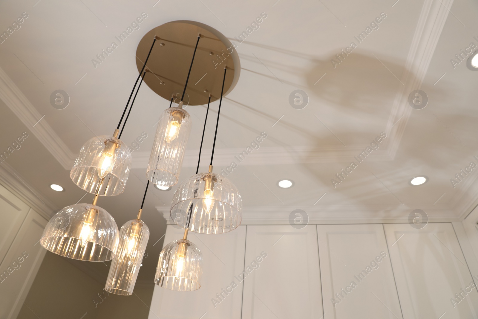 Photo of Stylish pendant lamp with light bulbs on ceiling in  modern room