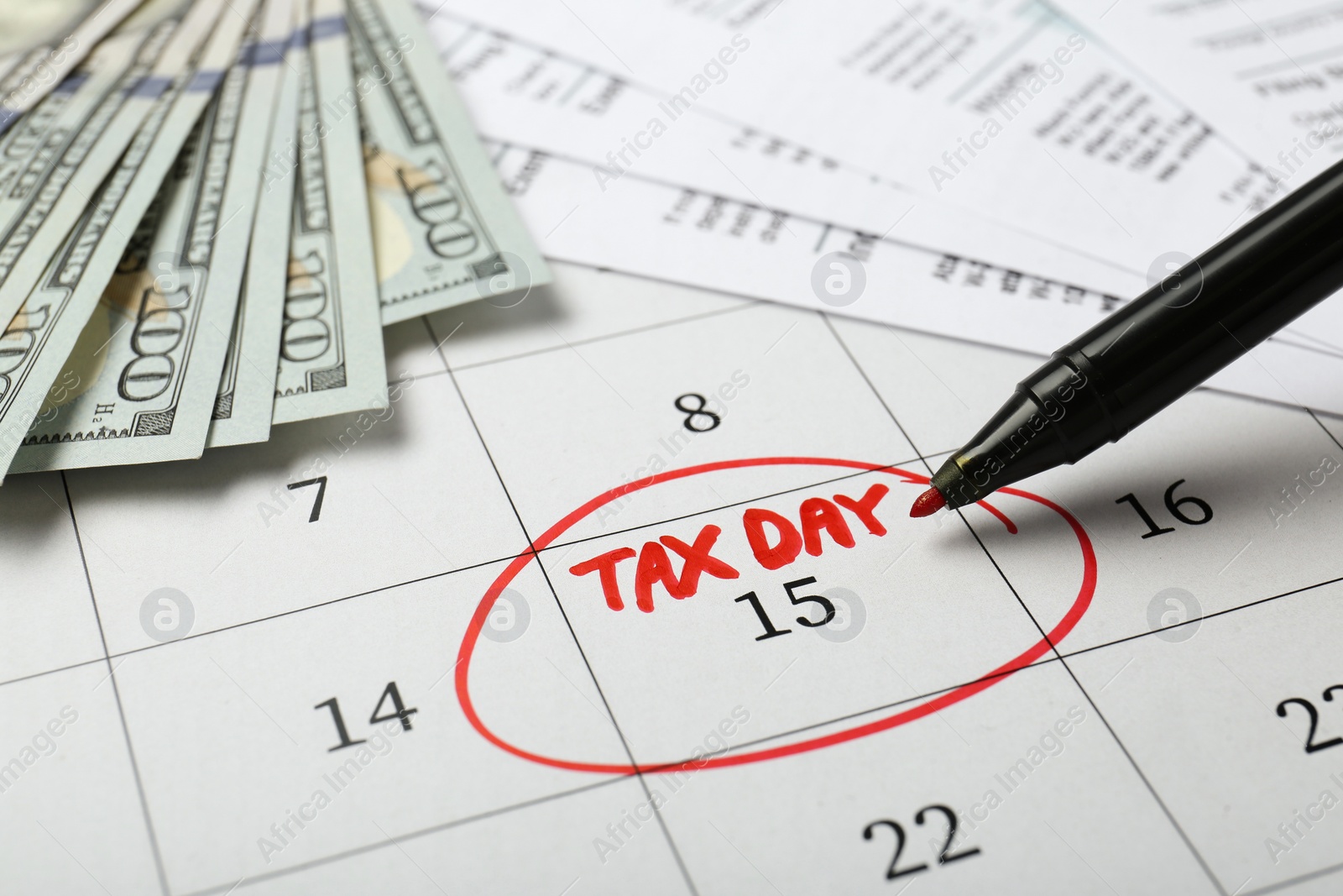 Photo of Marking tax day in calendar, felt pen, documents and money, closeup