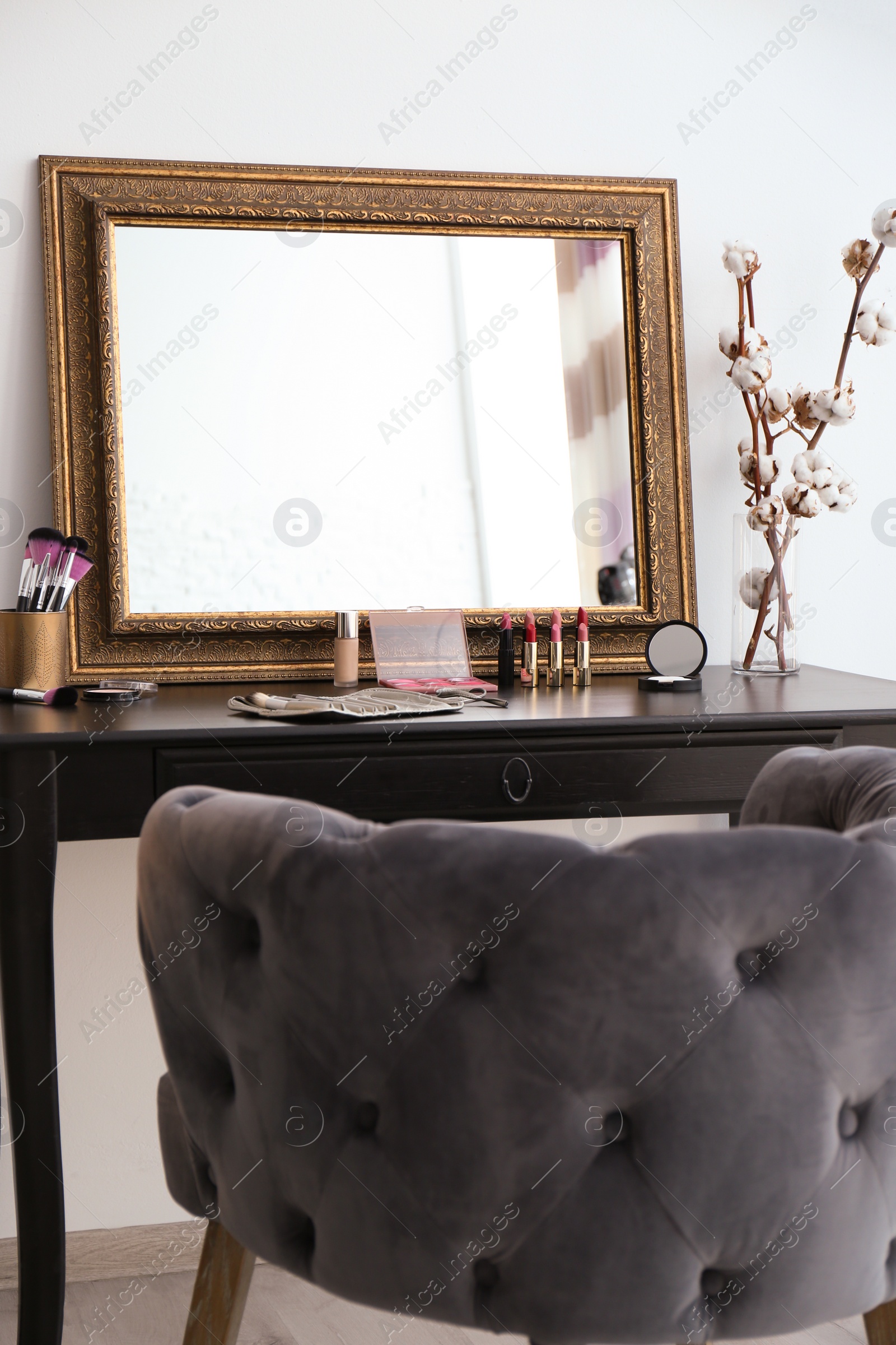 Photo of Dressing table with mirror and cosmetics in makeup room