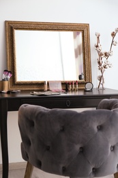 Photo of Dressing table with mirror and cosmetics in makeup room