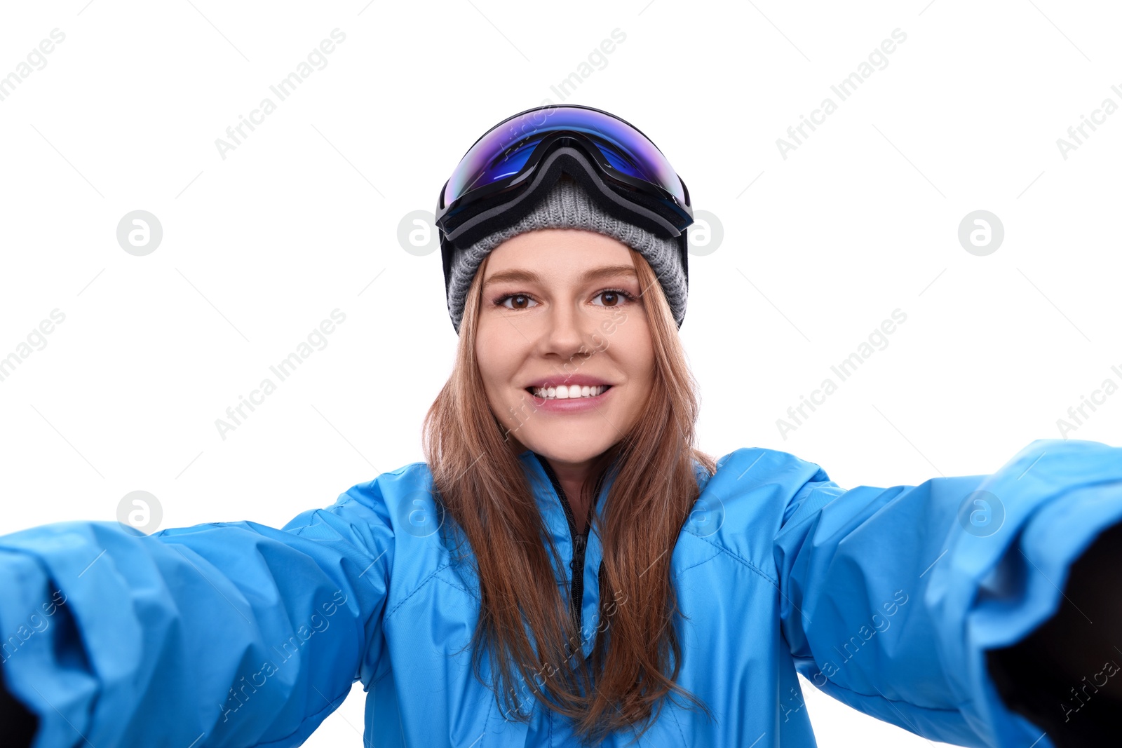 Photo of Beautiful woman in ski goggles taking selfie on white background