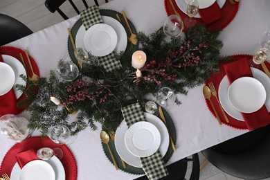 Christmas table setting with festive decor and dishware, top view