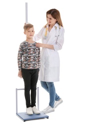 Photo of Doctor measuring little boy's height on white background