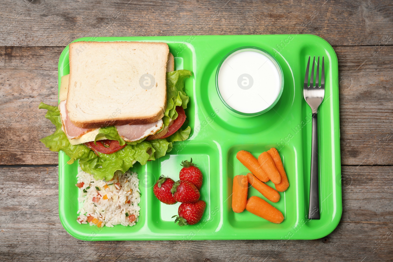 Photo of Tray with healthy food for school child on wooden background, top view