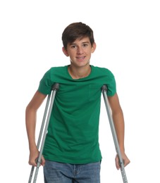 Photo of Teenage boy with injured leg using crutches on white background
