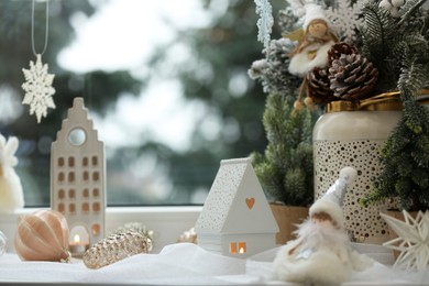 Photo of Many beautiful Christmas decorations and fir branches on window sill indoors