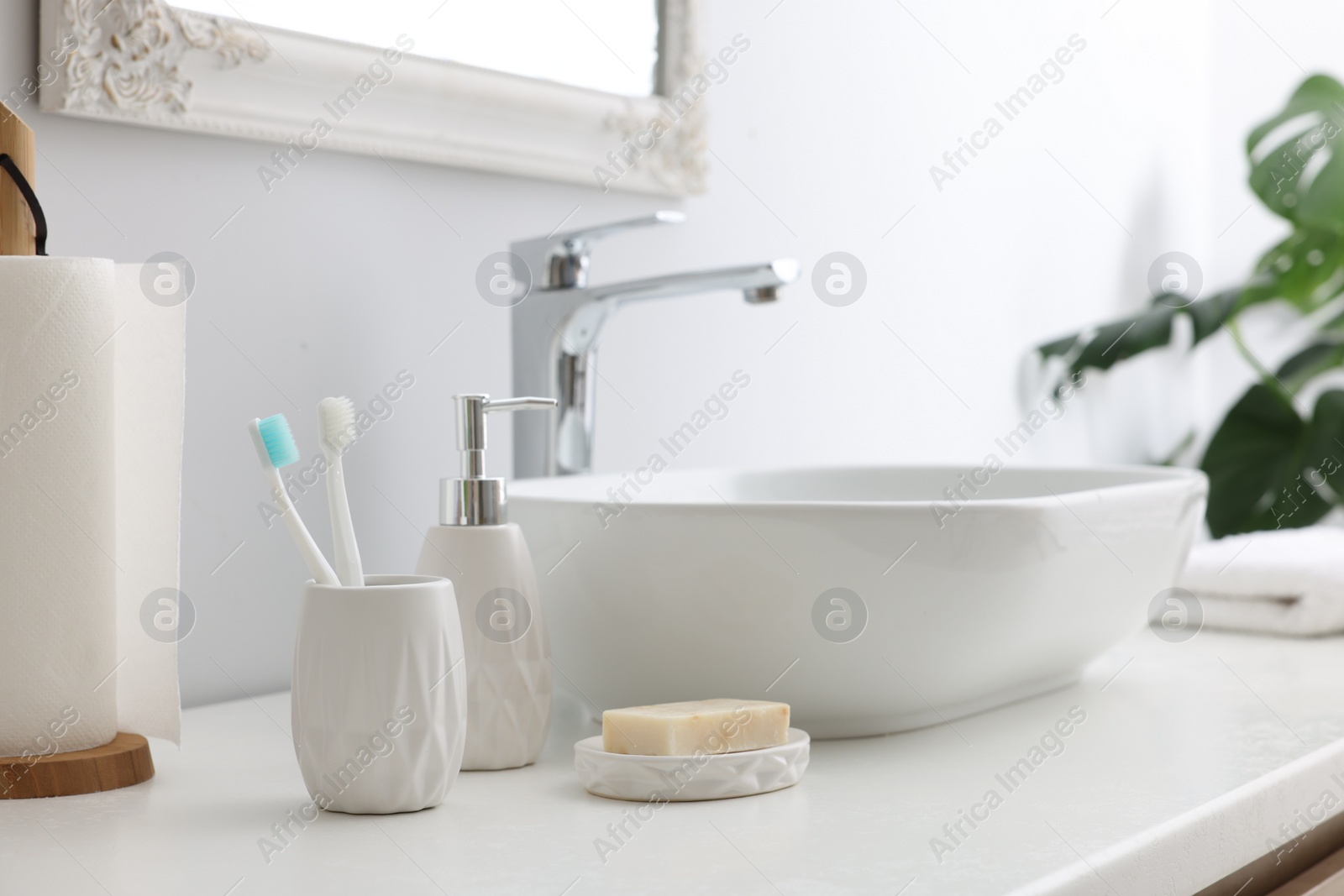 Photo of Different bath accessories and personal care products near sink on bathroom vanity