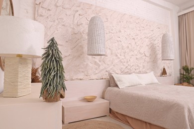 Photo of Stylish bedroom interior with small decorative Christmas tree