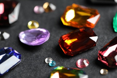 Photo of Beautiful gemstones for jewelry on dark background, closeup