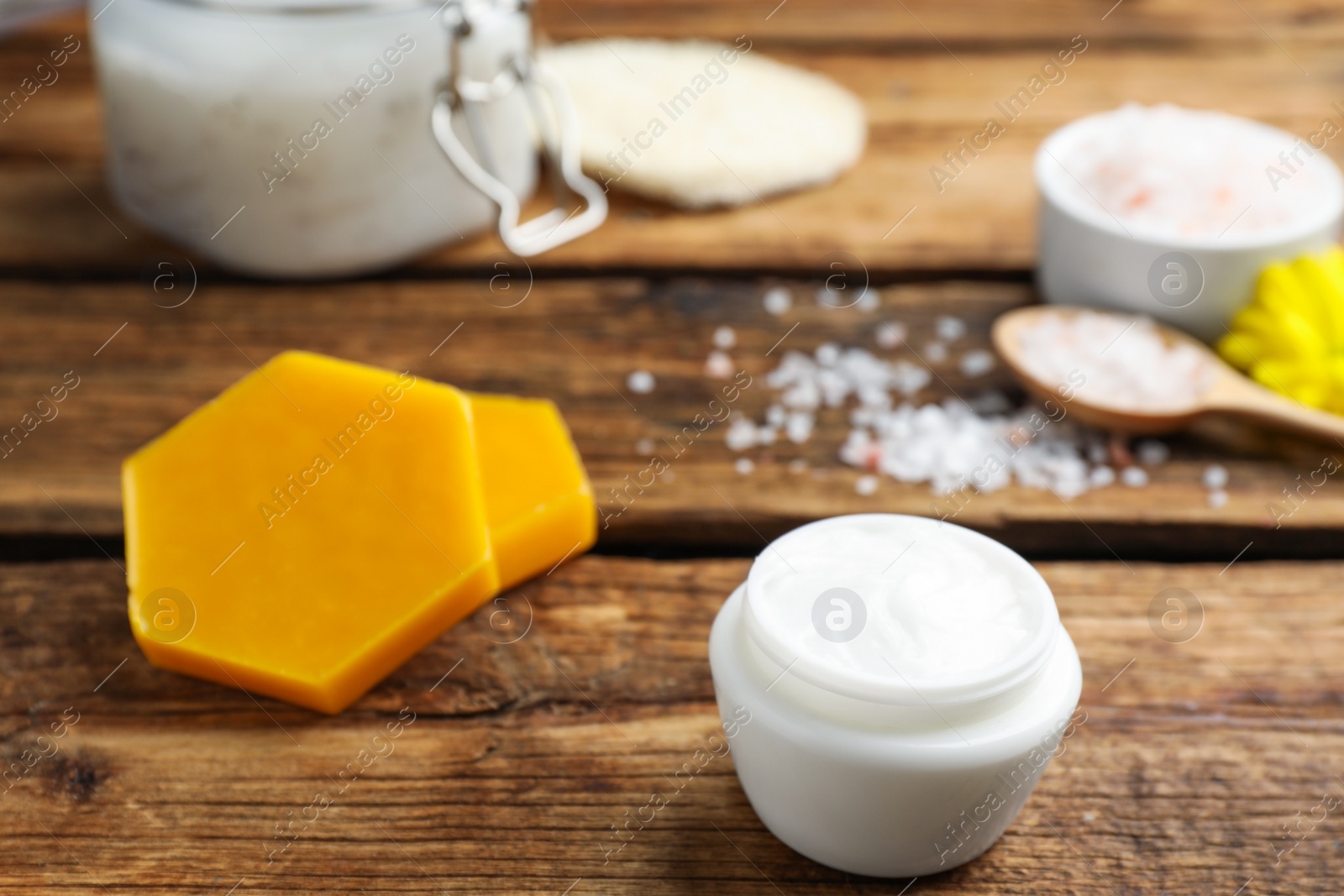 Photo of Cream with natural beeswax component on wooden table, closeup