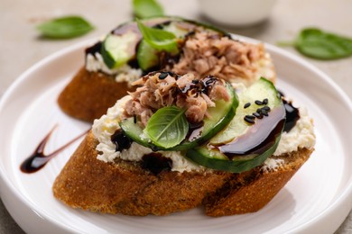 Delicious bruschettas with balsamic vinegar and toppings on table, closeup