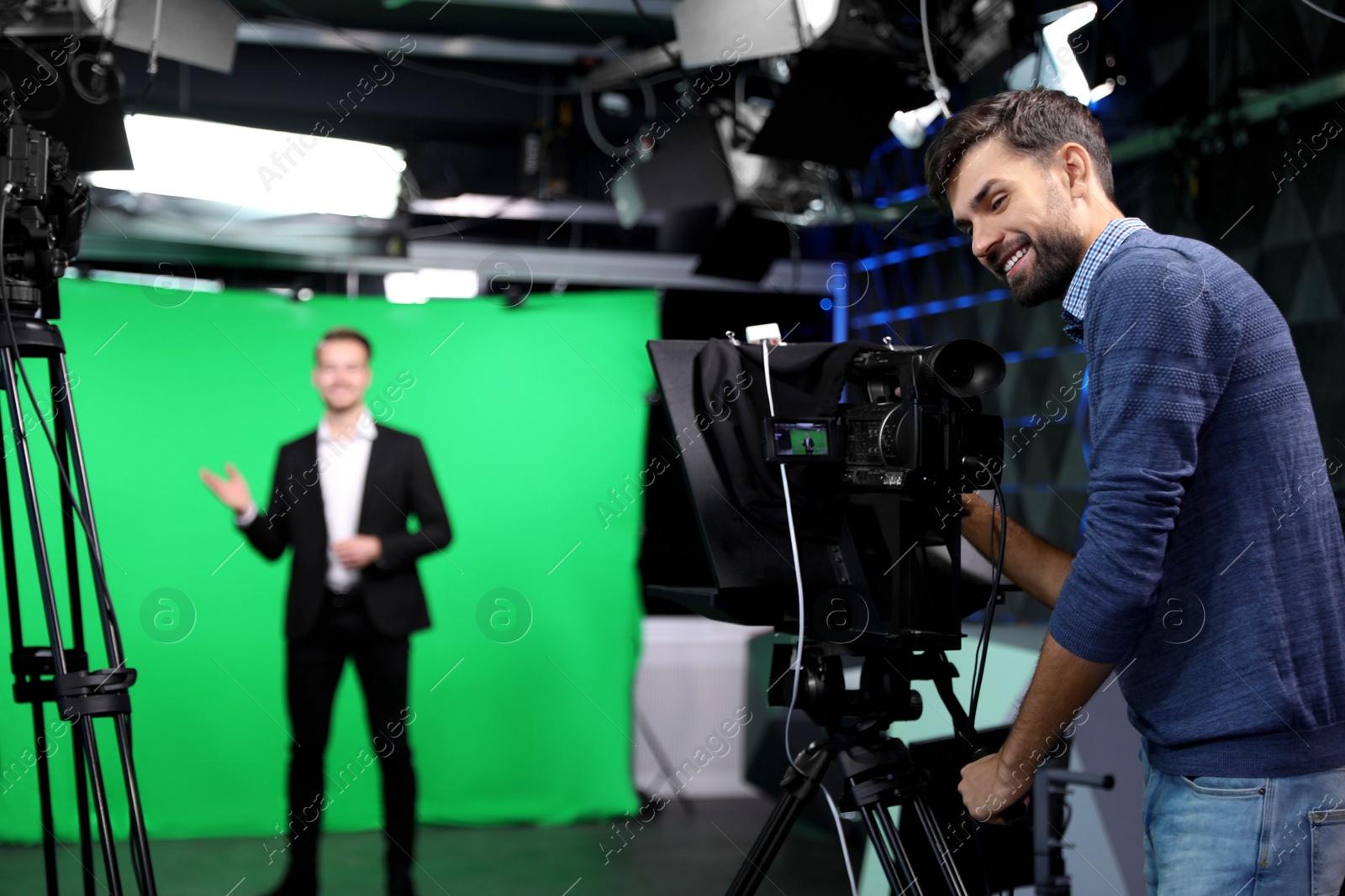 Photo of Presenter and video camera operator working in studio. News broadcasting