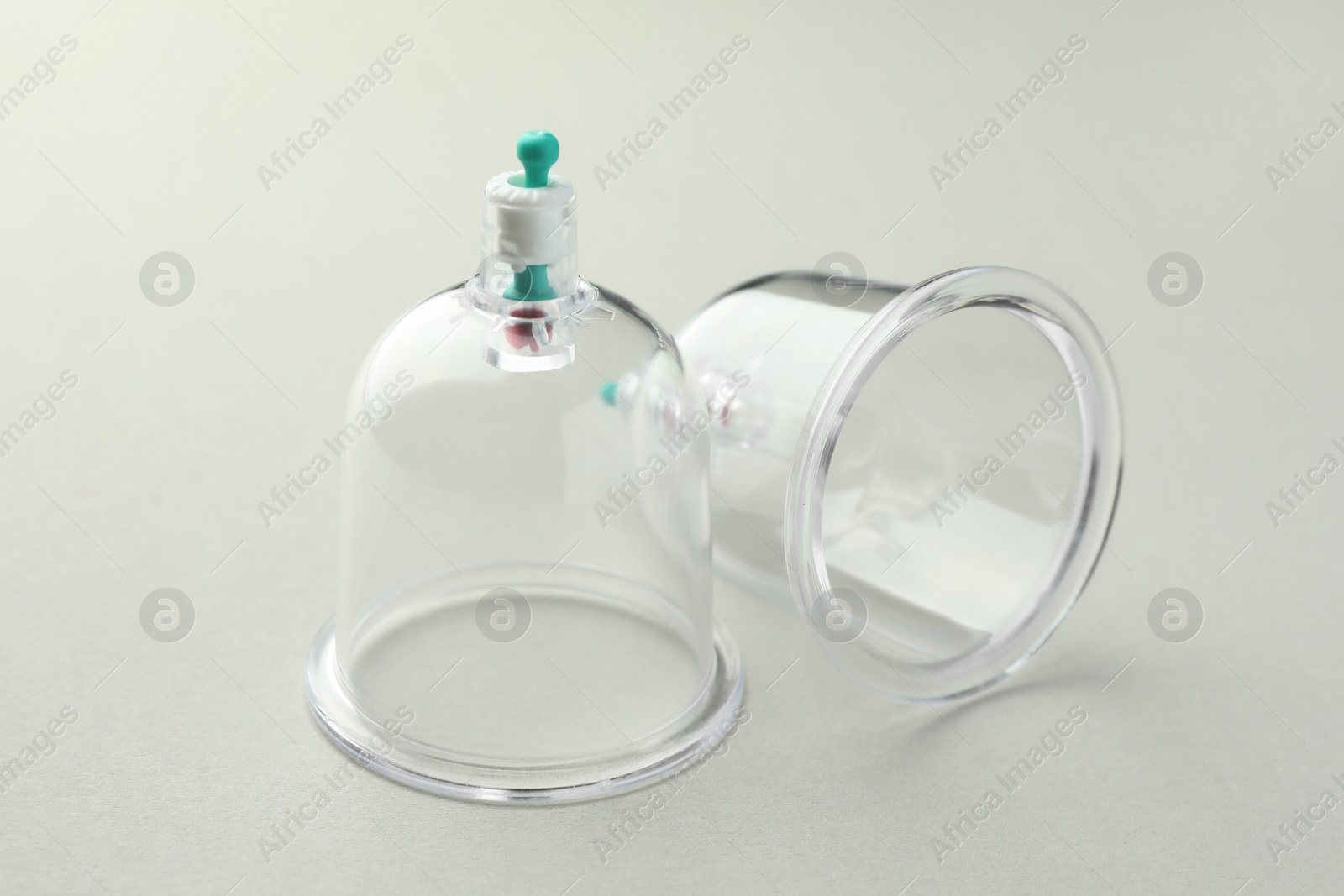 Photo of Plastic cups on light grey background, closeup. Cupping therapy