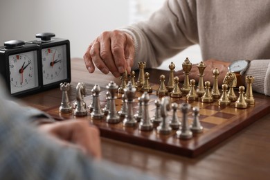 Men playing chess during tournament at table, closeup