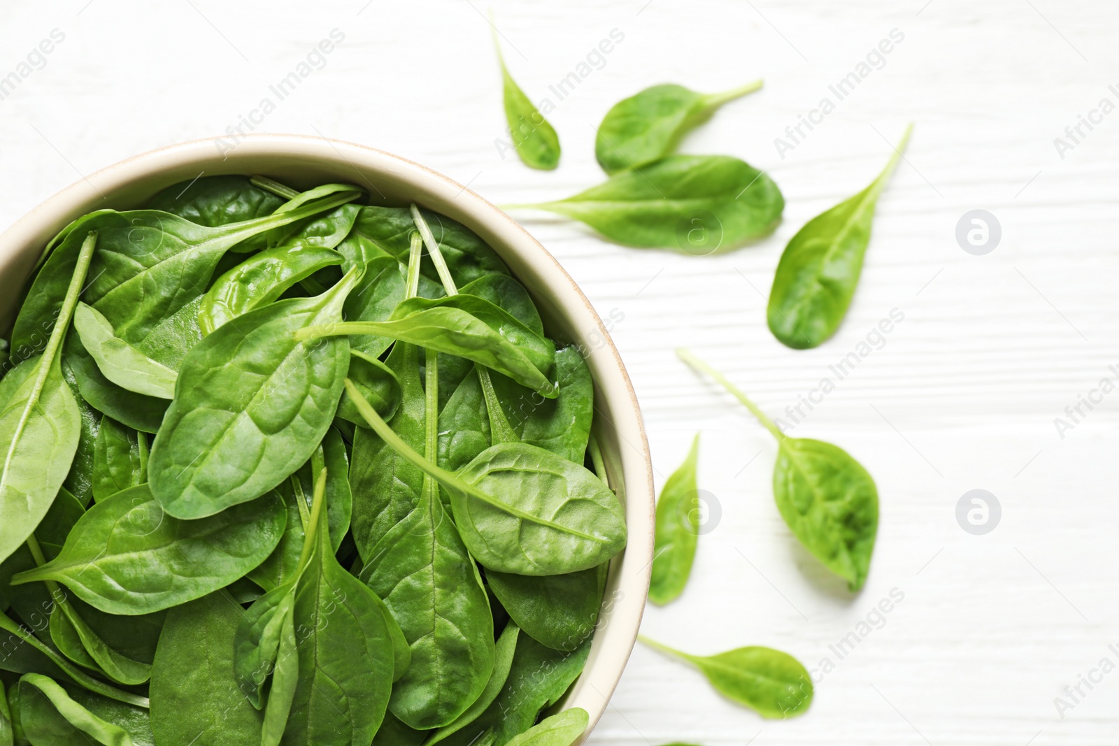 Photo of Fresh green healthy spinach on white wooden table, top view. Space for text