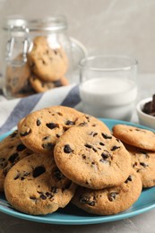Photo of Plate with delicious chocolate chip cookies on grey marble table, closeup