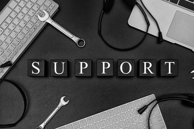 Photo of Cubes with word "SUPPORT" on dark background, flat lay composition. Technical service