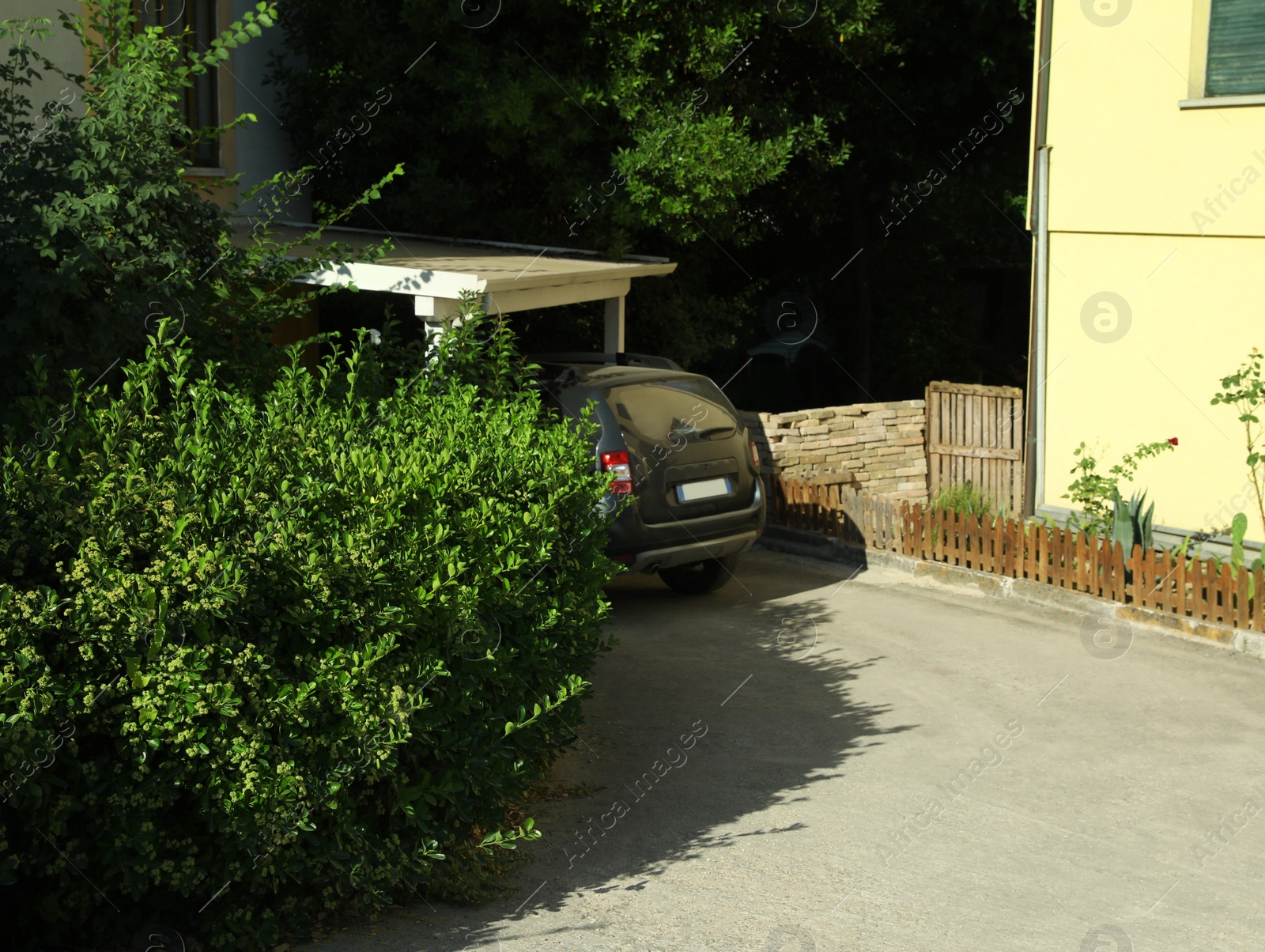 Photo of Car parked near building in yard on sunny day