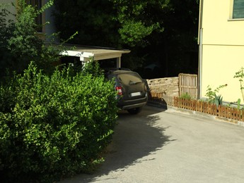 Photo of Car parked near building in yard on sunny day